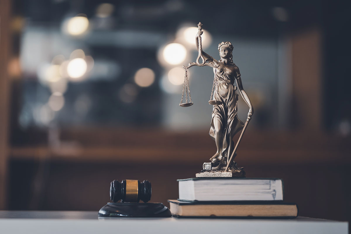 Ein Richterhammer und eine Statue Justice auf einem Tisch